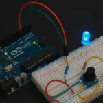 Arduino UNO z diodą LED, potencjometrem i płytką prototypową. Projekt elektroniczny, edukacja, Tinkercad.
